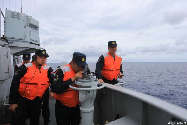 ▲海上航行补给，官兵位于驾驶室一侧观测操纵舰艇