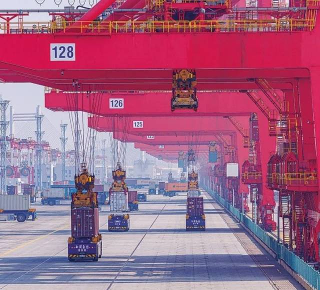 共建“一带一路”国家在工作制度对接、技术标准协调、检验结果互认等方面强化合作、统一标准,贸易自由化便利化水平不断提升。上海洋山港海关对接共建国家进出口货物相关标准,推动通关一体化方式申报,提升通关效率。图为无人驾驶的全自动导引车在洋山港穿梭往来,搬运集装箱。王初 摄 共建“一带一路”国家在工作制度对接、技术标准协调、检验结果互认等方面强化合作、统一标准,贸易自由化便利化水平不断提升。上海洋山港海关对接共建国家进出口货物相关标准,推动通关一体化方式申报,提升通关效率。图为无人驾驶的全自动导引车在洋山港穿梭往来,搬运集装箱。王初 摄