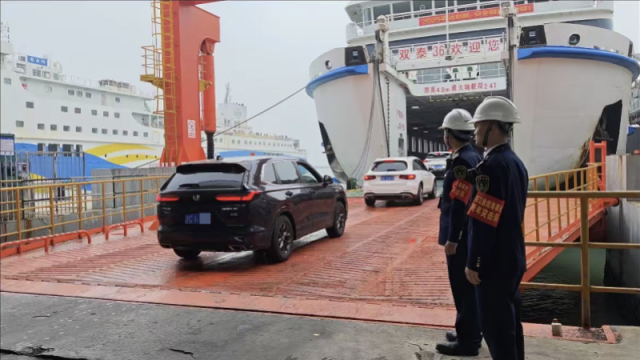 执法人员在琼州海峡维护车辆登船秩序。