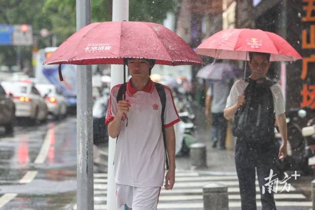 广州市天河区岳洲路，市民撑伞在雨中前行。