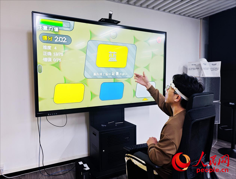广州琶洲实验室工作人员演示脑机接口设备如何操作专注力训练游戏。人民网 朴馨语摄 广州琶洲实验室工作人员演示脑机接口设备如何操作专注力训练游戏。人民网 朴馨语摄