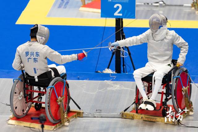广东选手黄晋冬（右）在男子个人佩剑C级金牌赛中以15:13的比分险胜广东队友罗兴东，成功夺金。
