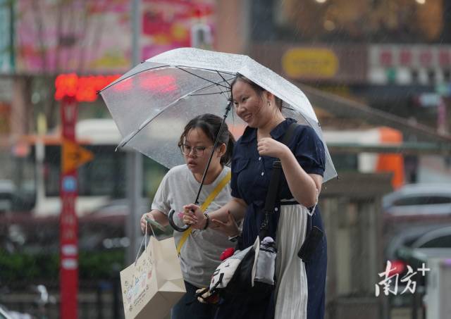 广州海珠区新港东迎来强对流天气，市民在暴雨中赶路。  