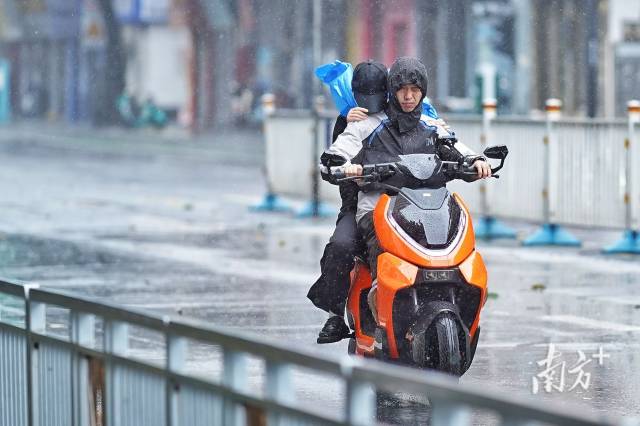 卫国路,强风暴雨让骑电动车的人睁不开眼。戴嘉信 摄