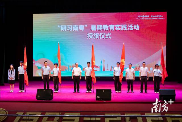 为实践团队学生代表授旗。