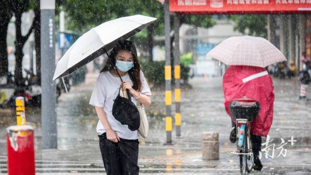 市民边走边拽着裤子以防弄湿裤脚。