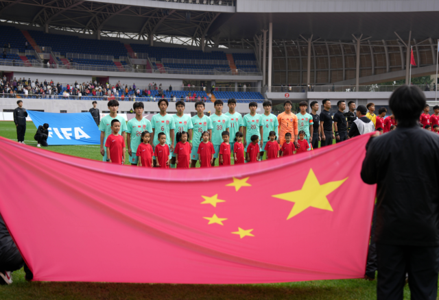 9月27日，中国男足球员在比赛前唱国歌。新华社发